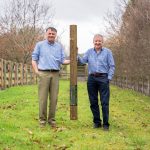 Postsaver founders Richard and Jim George holding a wooden post fitted with a Postsaver rot protector at The Hawthorns Business Centre.
